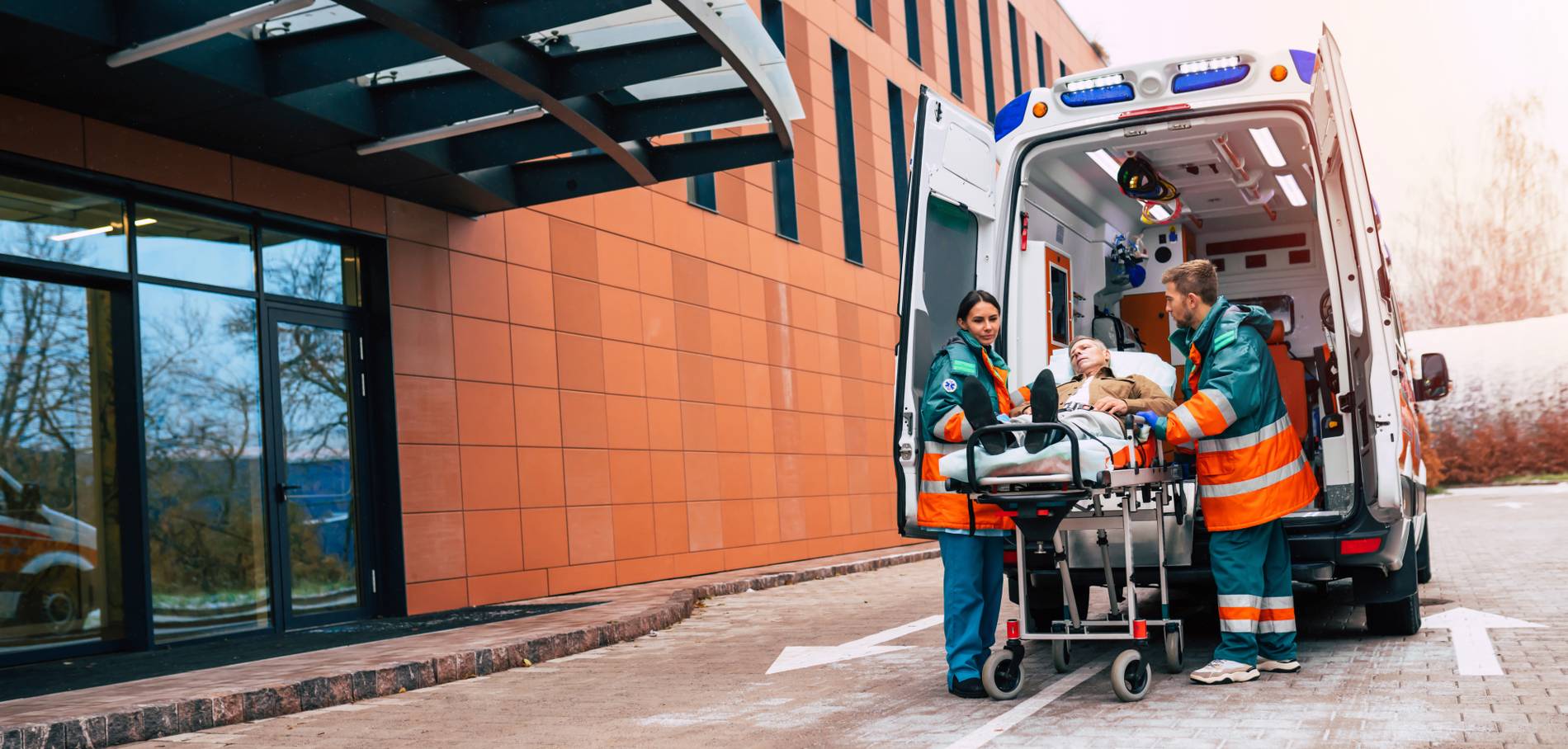 serious-professional-team-doctors-ambulance-moving-patient-into-hospital-during-emergency-situation_1900x908